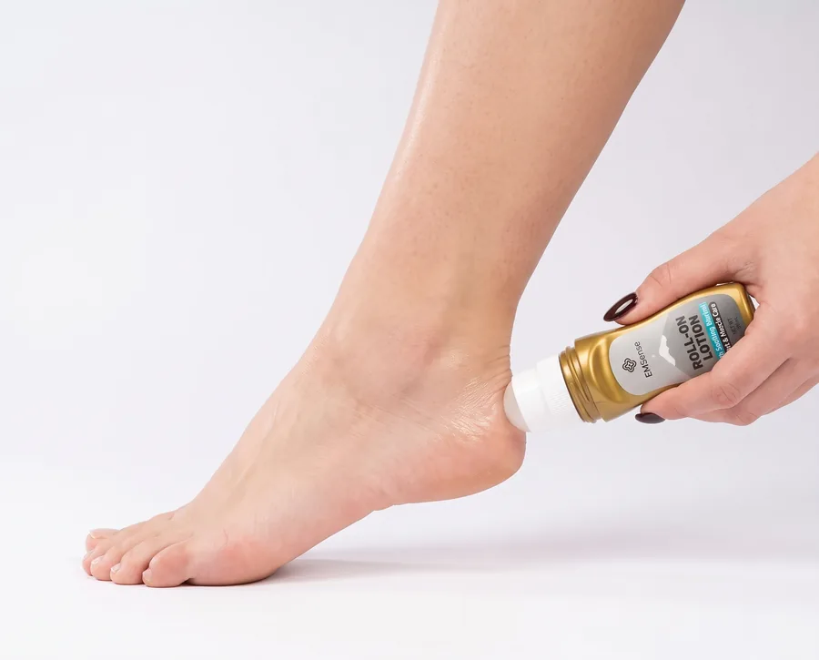 Applying EMSense Roll-On Lotion to the heel