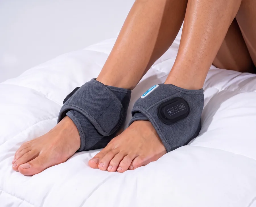 Both feet in EMSense wraps, resting on a bed